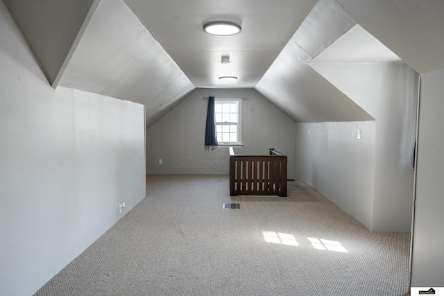 additional living space with vaulted ceiling, carpet flooring, and visible vents