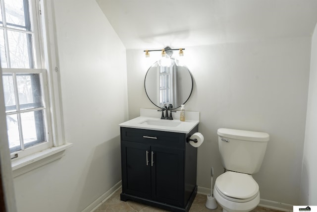 half bath featuring toilet, vanity, and baseboards