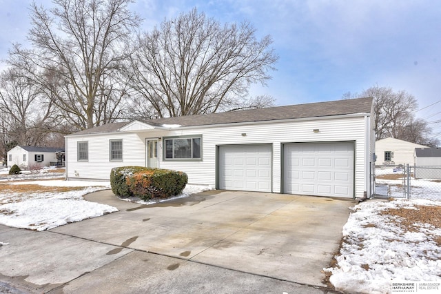 ranch-style home with a garage, driveway, and fence