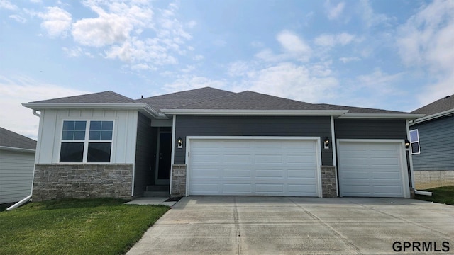 view of front of property with concrete driveway, a shingled roof, board and batten siding, and an attached garage