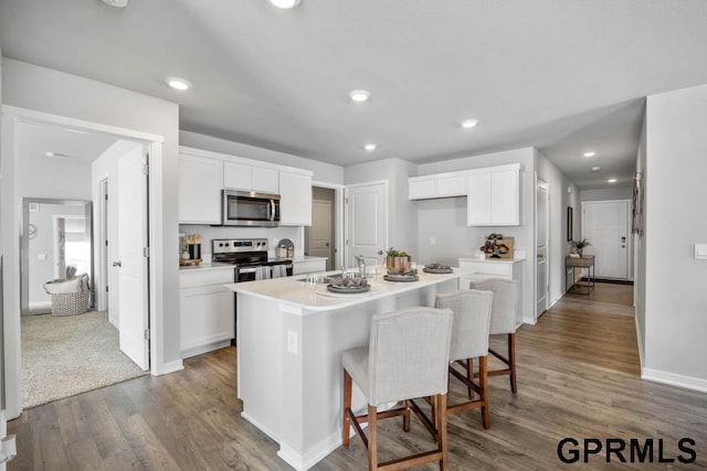 kitchen featuring appliances with stainless steel finishes, a sink, and white cabinetry