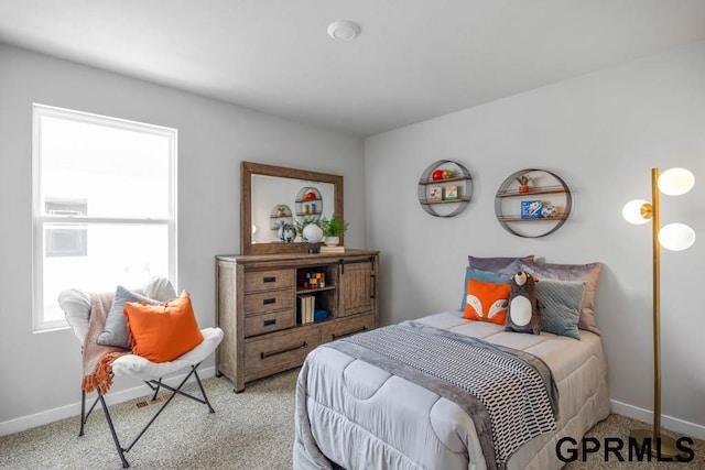 bedroom with baseboards and light colored carpet