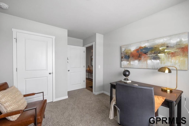 carpeted home office featuring baseboards