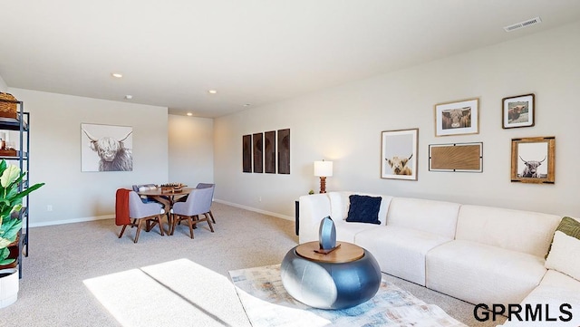 carpeted living area with recessed lighting, visible vents, and baseboards