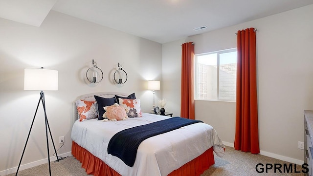 bedroom with baseboards, visible vents, and light colored carpet