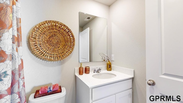 bathroom featuring visible vents, vanity, and toilet