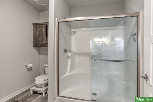 full bathroom with toilet, wood finished floors, a shower stall, and visible vents