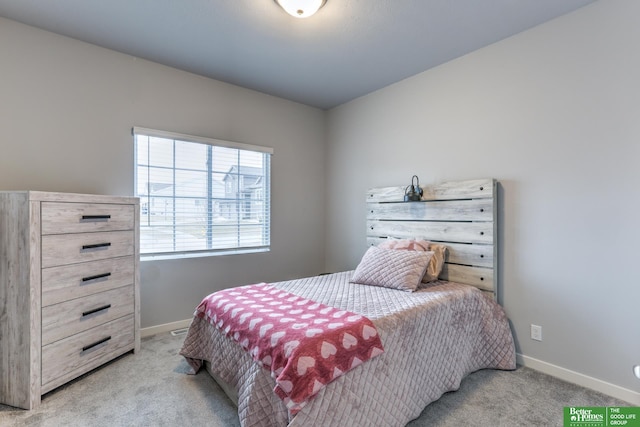 bedroom with baseboards and light colored carpet