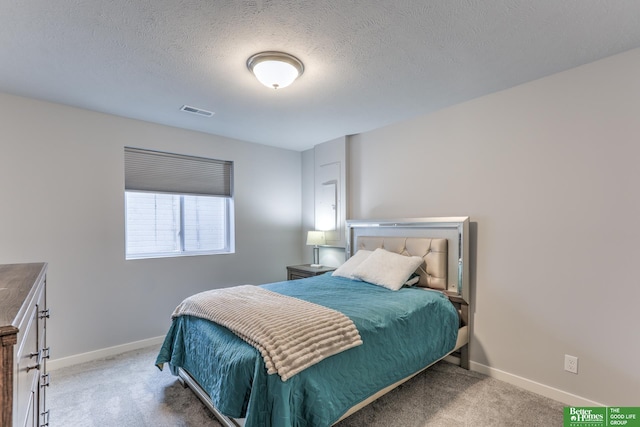 bedroom featuring carpet, visible vents, a textured ceiling, and baseboards