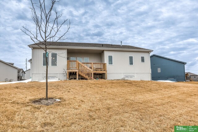 rear view of property with crawl space, roof with shingles, and a yard