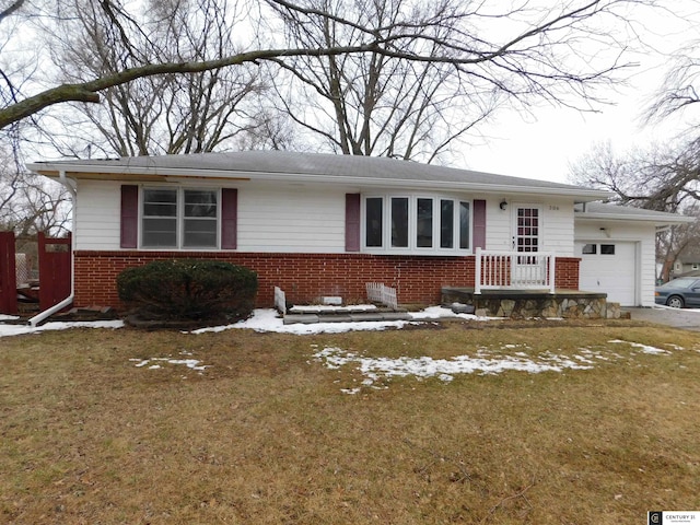 single story home with an attached garage, a front lawn, and brick siding