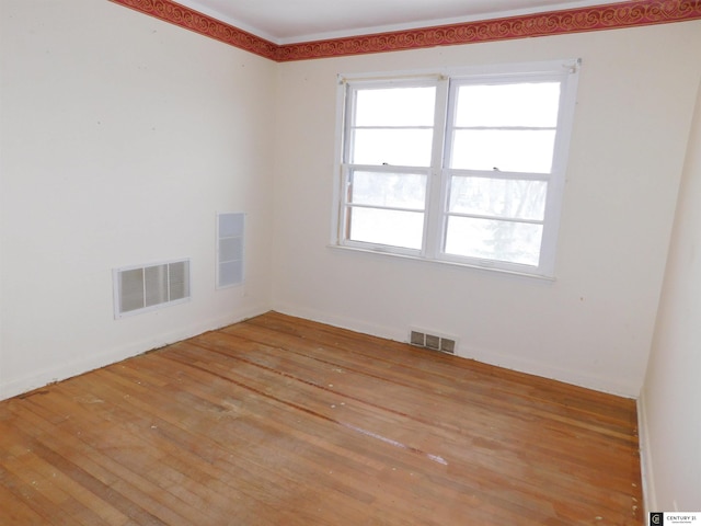 empty room featuring light wood-type flooring and visible vents