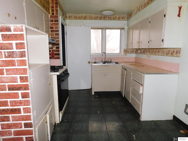 kitchen featuring white cabinets, light countertops, extractor fan, a sink, and gas stove