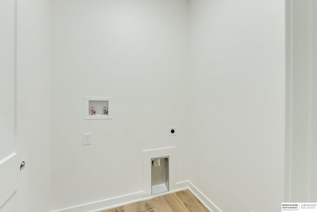 clothes washing area with laundry area, baseboards, light wood-style flooring, hookup for a washing machine, and electric dryer hookup