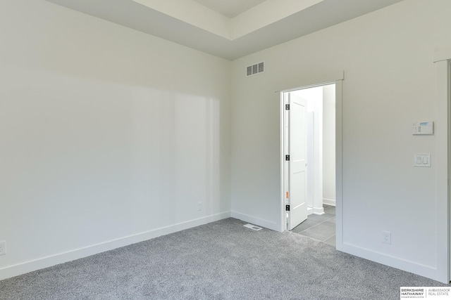 spare room featuring baseboards, visible vents, and carpet flooring