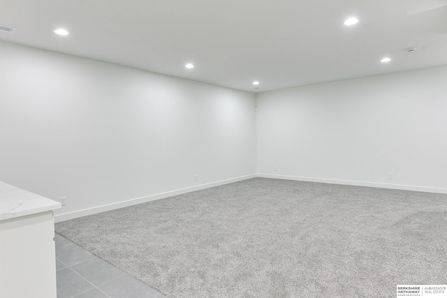 carpeted spare room featuring baseboards, visible vents, and recessed lighting