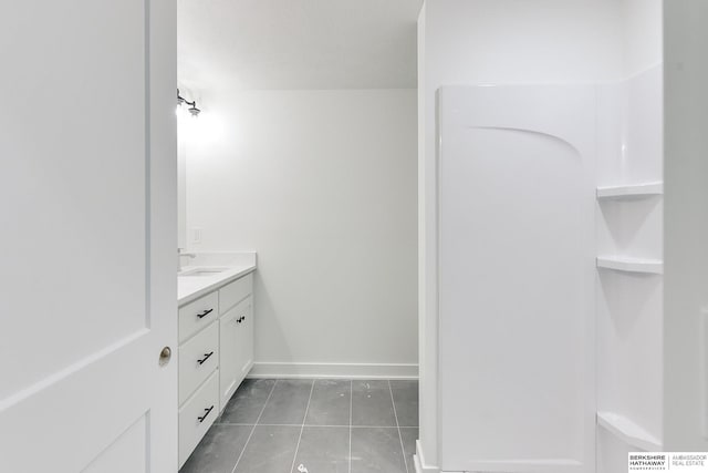 bathroom with vanity, baseboards, and tile patterned floors