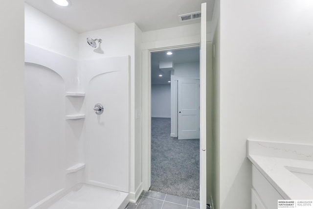 bathroom with vanity, tile patterned flooring, walk in shower, and visible vents