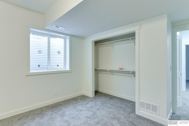 unfurnished bedroom with a closet, carpet flooring, and visible vents