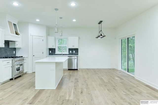 kitchen featuring appliances with stainless steel finishes, light wood-style flooring, and white cabinets