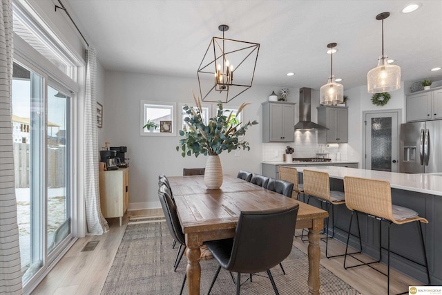 dining space featuring light wood-style floors, visible vents, and a healthy amount of sunlight