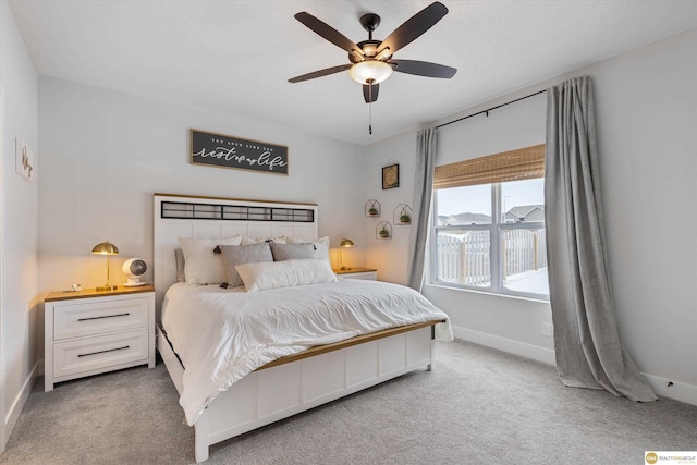 carpeted bedroom with ceiling fan and baseboards