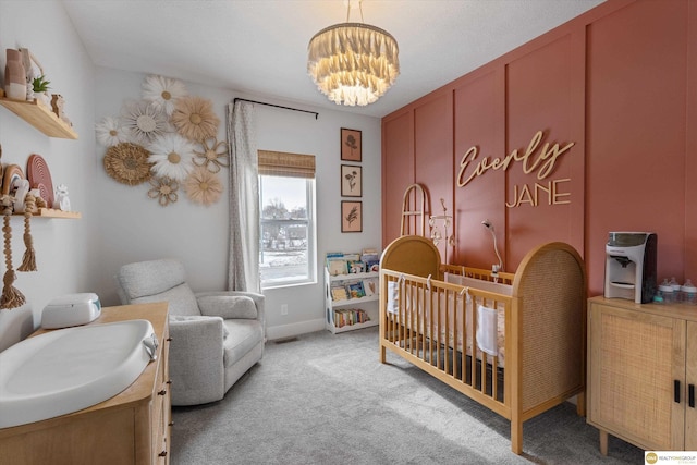 bedroom featuring a nursery area, light carpet, visible vents, and an inviting chandelier