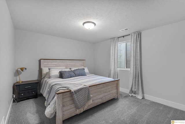 carpeted bedroom featuring visible vents, a textured ceiling, and baseboards