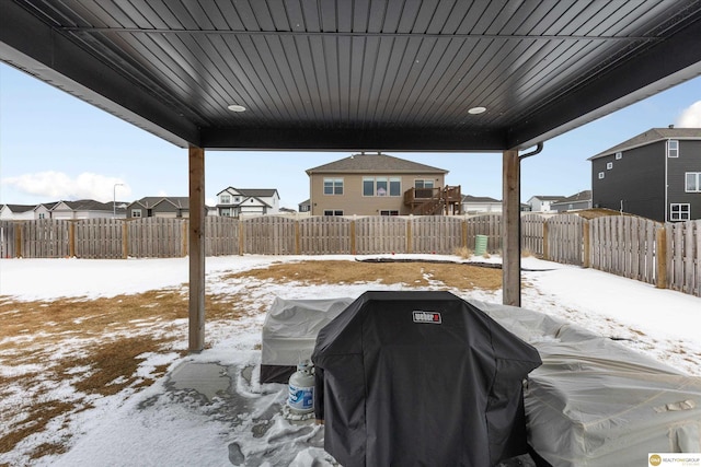 yard layered in snow featuring a residential view and a fenced backyard