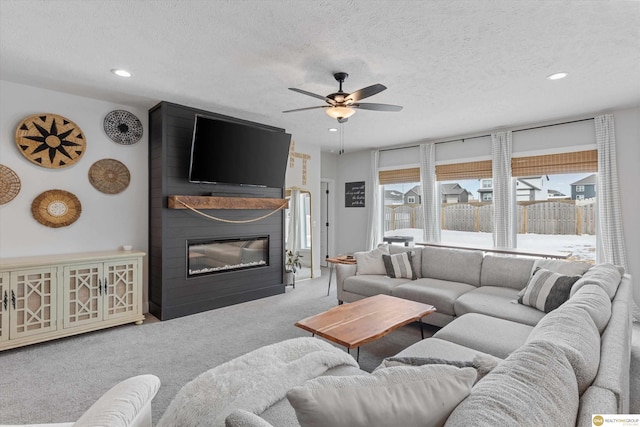 carpeted living room with recessed lighting, a fireplace, a textured ceiling, and ceiling fan