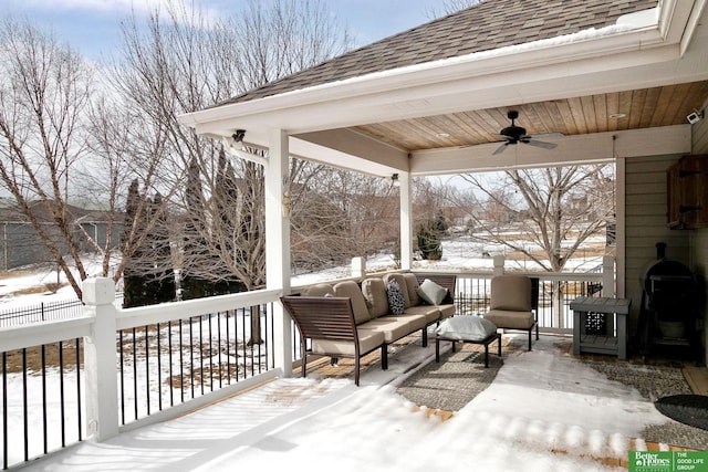 snow covered deck featuring ceiling fan, an outdoor living space, and fence