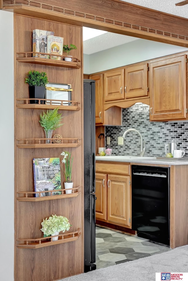 bar featuring tasteful backsplash, a textured ceiling, black appliances, and light floors