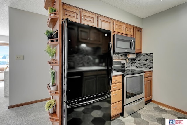 kitchen with a textured ceiling, baseboards, light countertops, appliances with stainless steel finishes, and tasteful backsplash