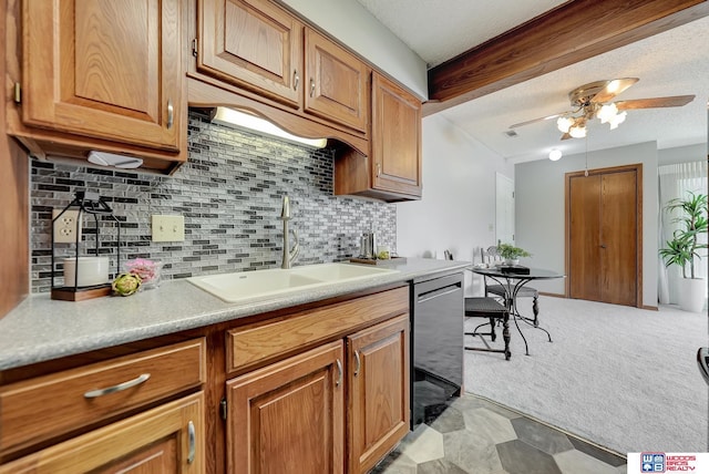 kitchen with dishwashing machine, light carpet, a sink, light countertops, and decorative backsplash