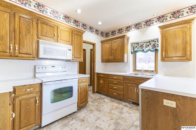 kitchen featuring light countertops, white appliances, brown cabinets, and a sink