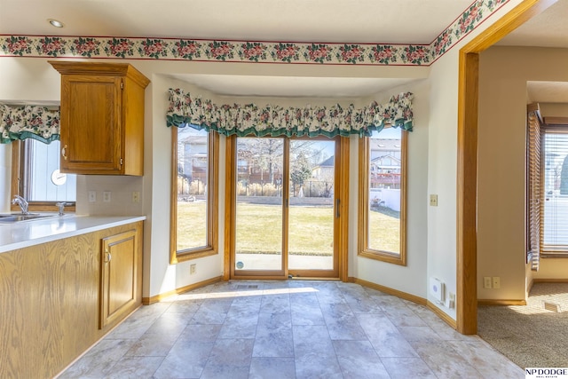 unfurnished dining area featuring a sink and baseboards