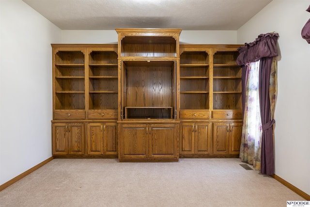 unfurnished living room featuring baseboards, visible vents, and light colored carpet