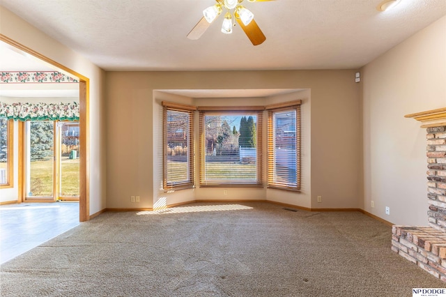 unfurnished living room with carpet, visible vents, a ceiling fan, a textured ceiling, and baseboards