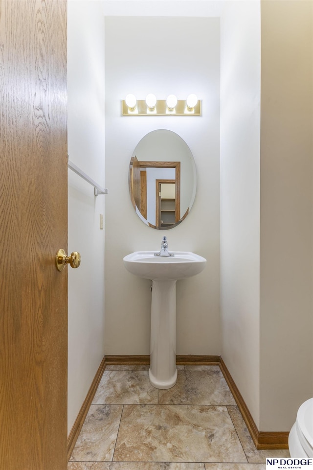 bathroom featuring toilet and baseboards