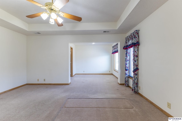 unfurnished room with visible vents, baseboards, and a raised ceiling