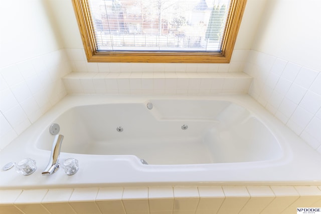 bathroom with a jetted tub and plenty of natural light