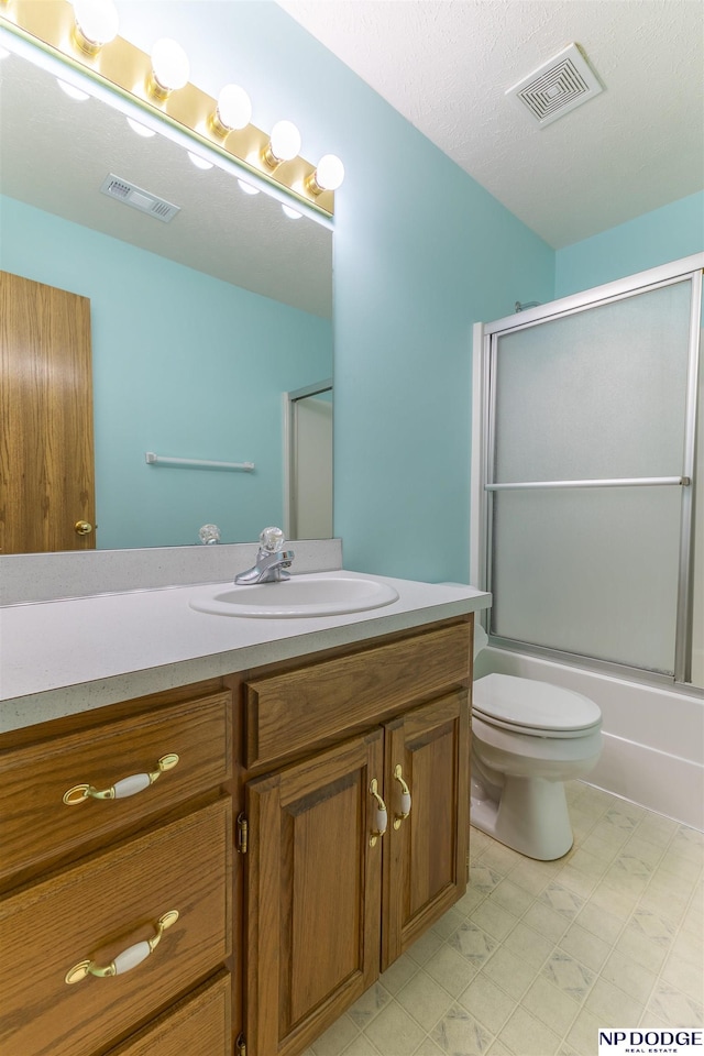 bathroom with toilet, vanity, visible vents, and enclosed tub / shower combo