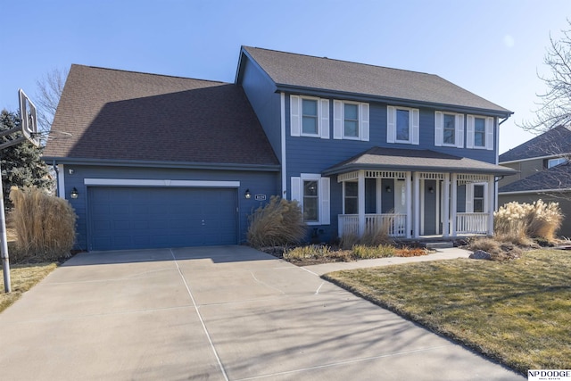 colonial inspired home with a garage, a shingled roof, concrete driveway, covered porch, and a front lawn