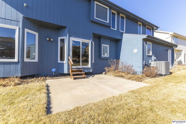 back of property with central air condition unit, a patio area, and a lawn