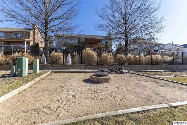 view of home's community featuring an outdoor fire pit and fence