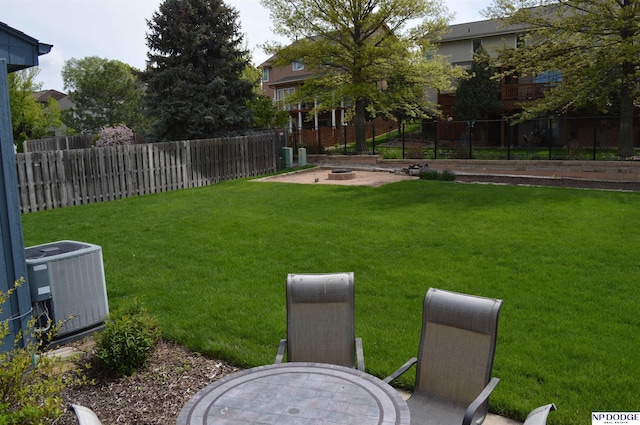 view of yard featuring an outdoor fire pit, a fenced backyard, and central AC