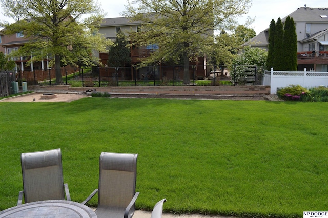 view of yard with an outdoor fire pit and fence