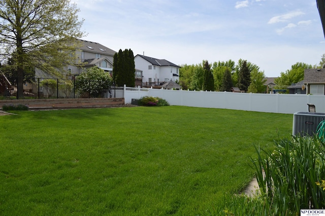 view of yard featuring cooling unit, a fenced backyard, and a residential view