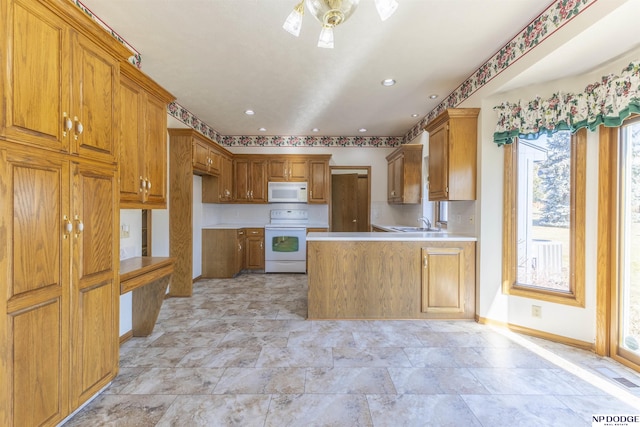 kitchen featuring brown cabinets, light countertops, white appliances, a peninsula, and baseboards