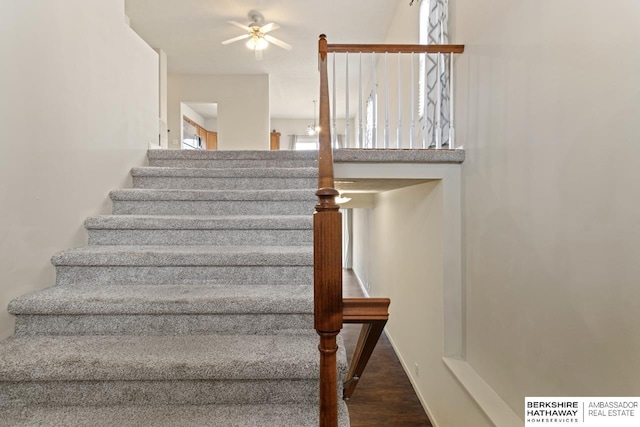 stairs featuring baseboards, a ceiling fan, and wood finished floors